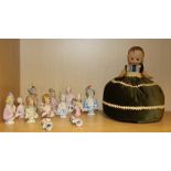 A group of fourteen porcelain half dolls, tallest 10cm, with a celluloid doll pin cushion, H. 22cm.