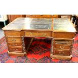 A superb 19th Century leather topped partners desk with drawers on one side and arched cupboards and