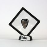 A heart cut 8ct smokey quartz in a Perspex display stand.