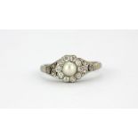 An early 20th century white metal (tested high carat gold) pearl and diamond set ring, (N.5).