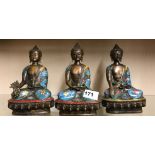 A set of three Chinese cloisonne on bronze figures of the seated Buddha, H. 20cm.