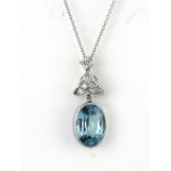 A white metal (tested high carat gold) pendant set with an old oval cut blue stone and diamonds on a