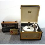 A vintage portable record player and two transistor radios.