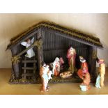 A mid 20th Century porcelain Nativity set with wooden manger, H. 26cm.