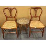 A pair of Victorian cane seated bedroom chairs and a small carved table.