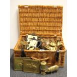 A picnic basket and brass and copper contents.