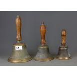 Three antique bronze bells, largest 27cm.