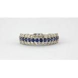 An 18ct white gold ring set with round cut sapphires and two rows of brilliant cut diamonds, (M.5).