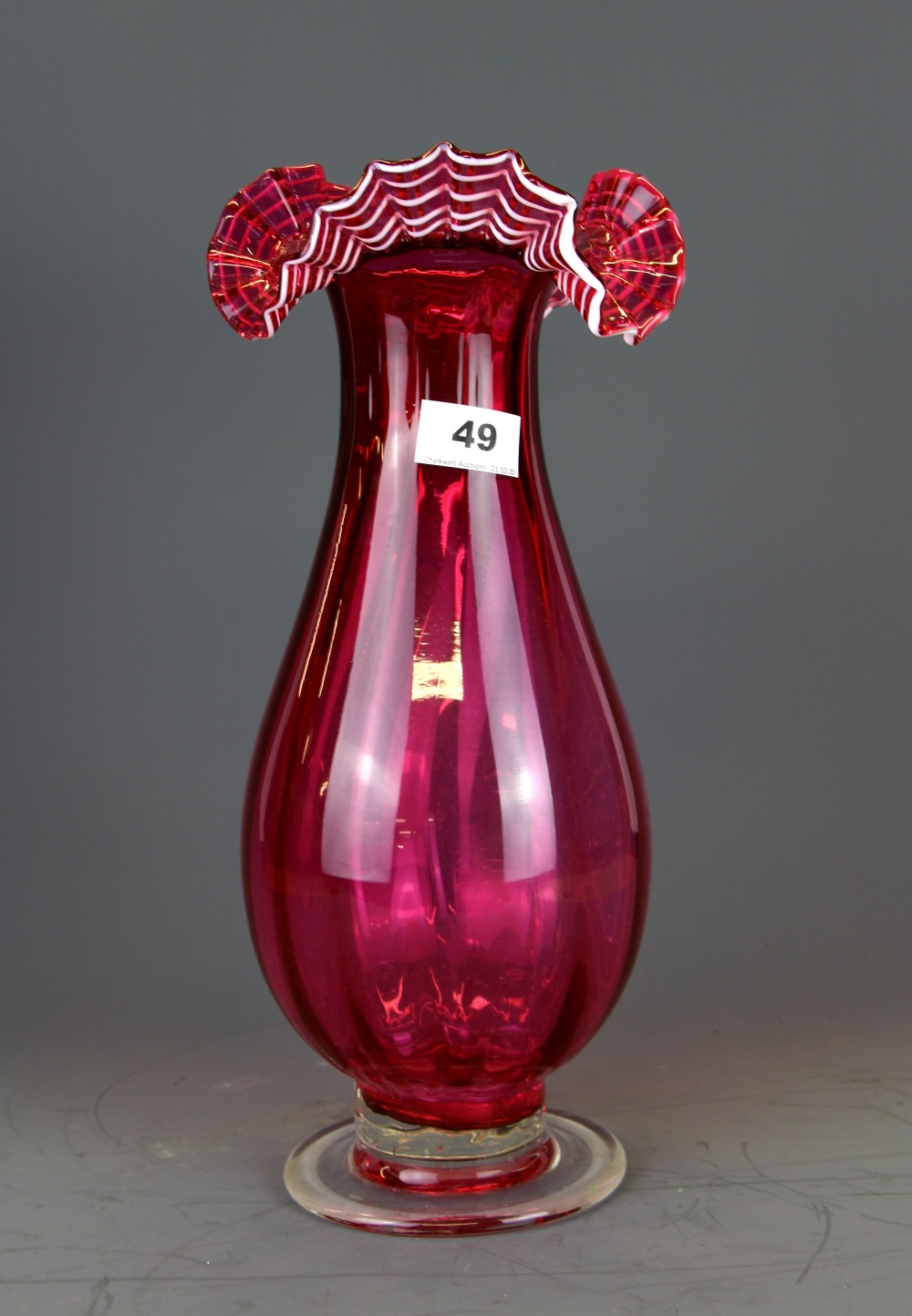 A superb 19th Century cranberry glass vase with 'ribbon' style rim with white detail, H. 37cm.