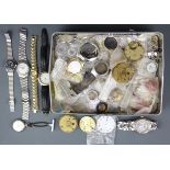 A tin of watches and watch movements.