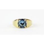 A 9ct yellow gold solitaire ring set with a blue topaz, (L.5).