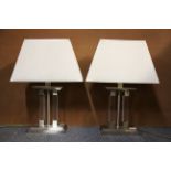 A pair of contemporary stainless steal glass tables lamps and shades, H. 55cm.