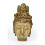 A Chinese carved wooden head of the goddess Guanyin with remnants of pigment, H. 22cm.