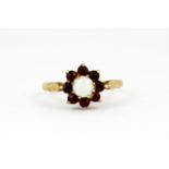 A 9ct yellow gold garnet and opal set cluster ring, (O).