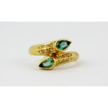 An 18ct yellow gold (stamped 750) ring set with pear cut green tourmalines and brilliant cut