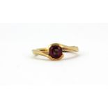 A yellow metal (tested 9ct gold) ring set with a pink stone, (P).