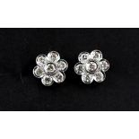 A pair of white metal (tested 18ct gold) daisy cluster earrings set with brilliant cut diamonds,