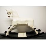 An old painted carved wooden rocking horse, H. 88cm.