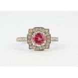 An 18ct white gold cluster ring set with a round cut pink tourmaline and brilliant cut diamonds, (
