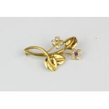 An 18ct yellow gold (stamped 750) brooch set with pink and yellow sapphires, L. 3.8cm.