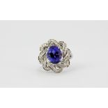 A 14ct white gold (stamped 585) ring set with a large oval cut tanzanite and brilliant cut diamonds,
