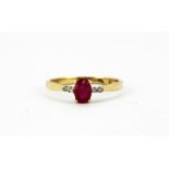 A 9ct yellow gold ring set with an oval cut ruby and brilliant cut diamond set shoulders, (N).