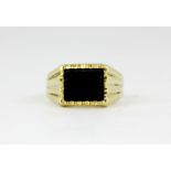 A gentleman's 9ct yellow gold onyx set ring, (T).