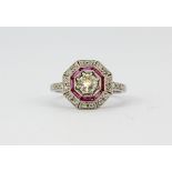 An 18ct white gold (stamped 18k) ring set with an old cut centre diamond surrounded by rubies and
