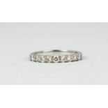An 18ct white gold diamond set half eternity ring, approx. 0.60ct, (L.5).