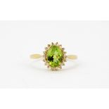 A 9ct yellow gold oval cut peridot and rose cut diamond set cluster ring, (M).