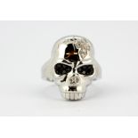 A 9ct white gold skull shaped ring set with diamonds and fancy black diamonds, (N).