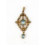 A yellow metal (tested 9ct gold) pendant set with split pearls and oval cut blue topaz, L. 5cm.