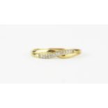 A 9ct yellow gold diamond set crossover ring, (P.5).