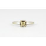 An 18ct white gold ring set with an 0.40ct cushion cut fancy light yellow diamond surrounded by