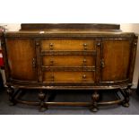 A 1920's carved oak bow front sideboard, W. 148cm. H. 100cm.