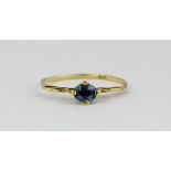 A 14ct yellow gold (stamped 585) solitaire ring set with an oval cut blue topaz, (O).