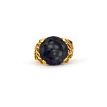 A yellow metal (tested 9ct gold) ring set with a synthetic alexandrite, (P).