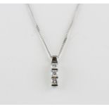 An 18ct white gold (stamped 750) pendant and chain set with three brilliant cut diamonds, L. 1.7cm.