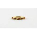 A 9ct yellow gold ruby and diamond set half eternity ring, (N.5).