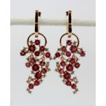 A pair of 925 silver rose gold gilt drop earrings set with round cut rubies and white stones, L.