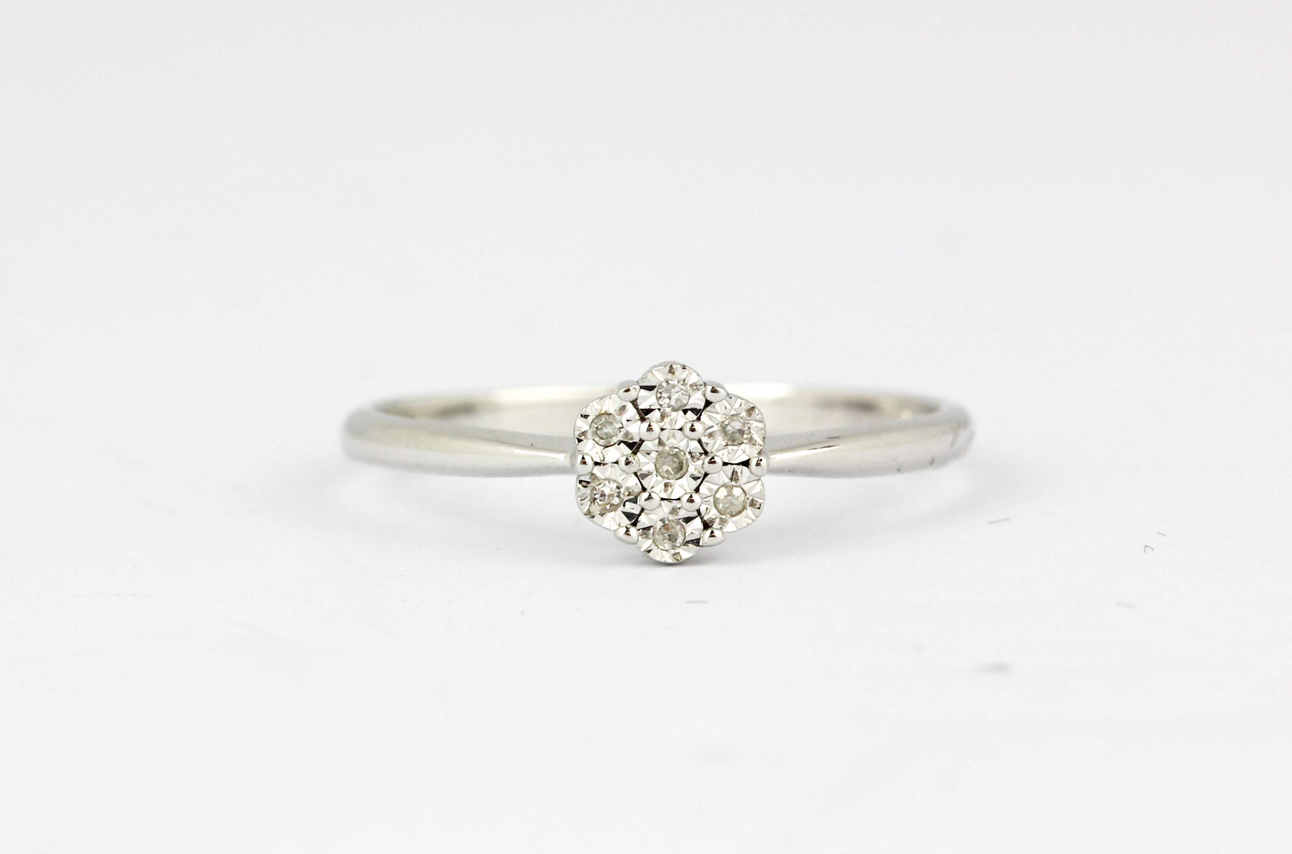 A 9ct white gold diamond set cluster ring, (M).