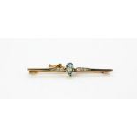 An yellow and white metal (tested 18ct gold) brooch set with an aquamarine and diamonds, L. 6cm.