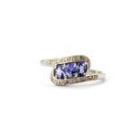 A 9ct white gold tanzanite and diamond set crossover ring, (N.5).