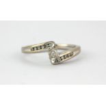 An 18ct white gold ring set with a brilliant cut diamond and diamond set shoulders, (P).