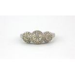 A 10ct white gold (stamped 10k) diamond set triple cluster ring, (J).