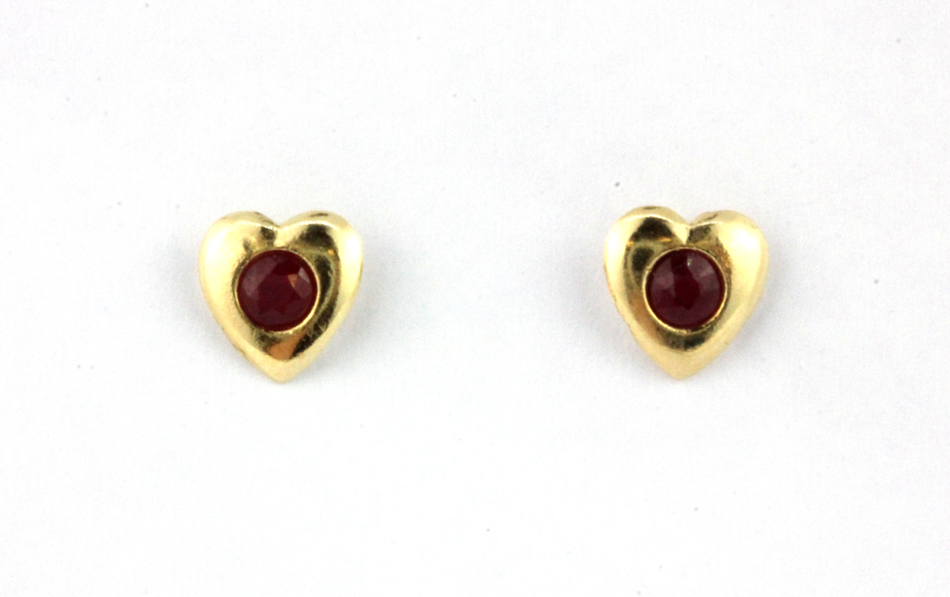 A pair of 9ct yellow gold ruby set heart shaped stud earrings, L. 0.7cm.