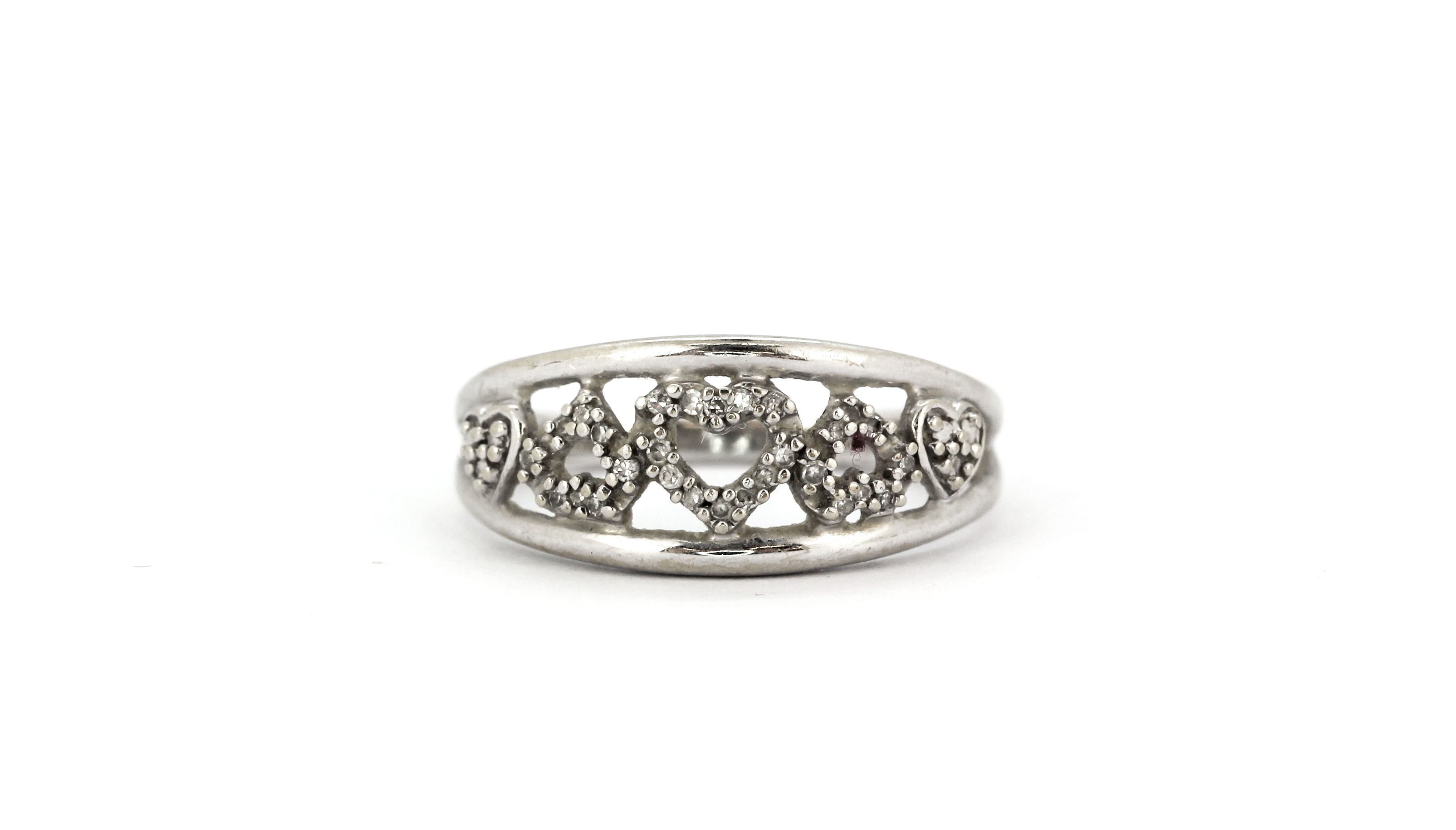 A 9ct white gold (stamped 10k) diamond set hearts ring, (M).