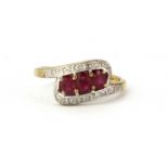 A 9ct yellow gold oval cut ruby and diamond set crossover ring, (M).