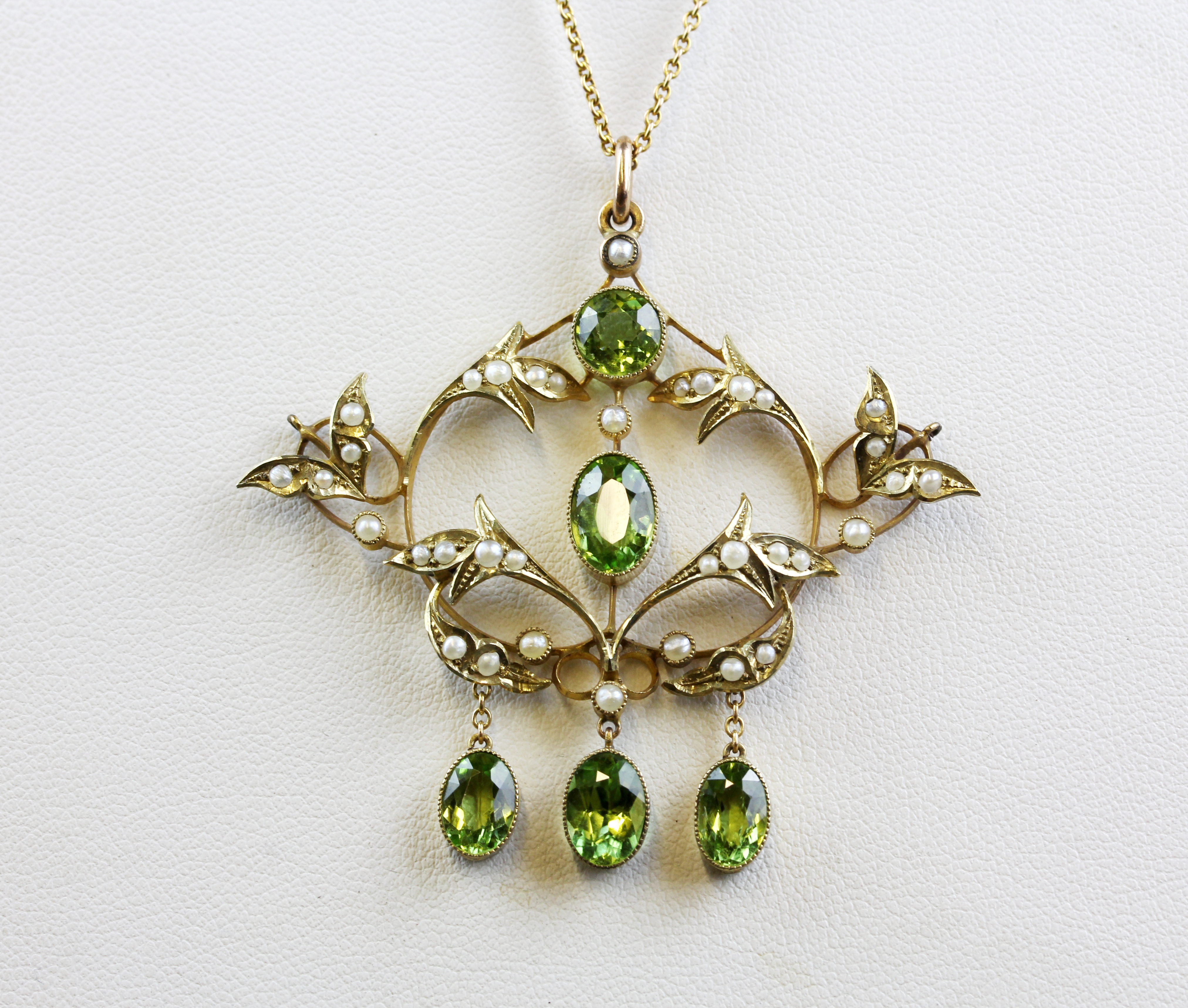 An Edwardian 9ct yellow gold (stamped 9ct) peridot and seed pearl set pendant and chain, L. 5 x 5.