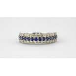 An 18ct white gold ring set with round cut sapphires and two rows of brilliant cut diamonds, (M.5).